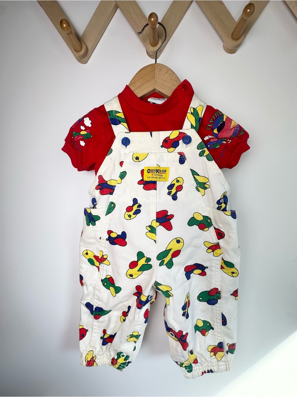 OshKosh B'gosh White Overalls with Colorful Airplane Print and Red Accents